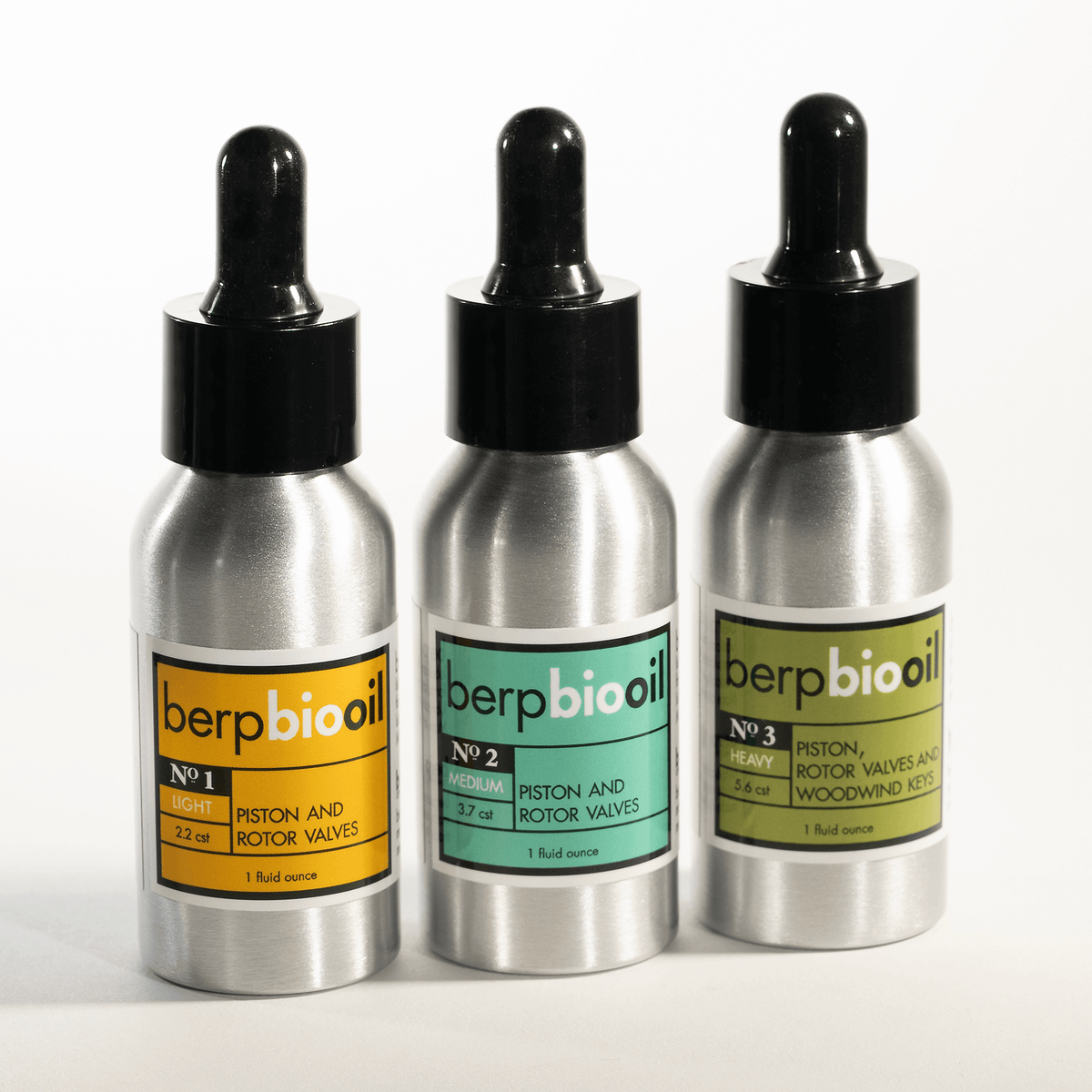 Three silver bottles with black dropper lids labeled 'berp bio oil' on a white background.